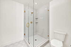 Bed 4 ensuite Bathroom with a shower with shower door, toilet, and tile patterned flooring