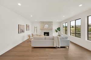 Living room featuring a stone fireplace and light hardwood / wood-style flooring