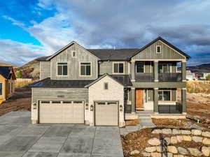 View of front facade featuring a mountain view, a garage, and a balcony