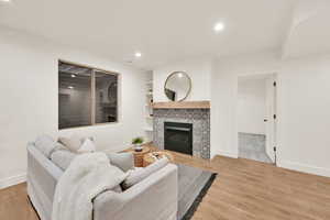 ADU Living room featuring light hardwood / wood-style floors, built in features, and a fireplace