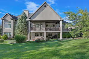 Rear view of property with deck and lawn