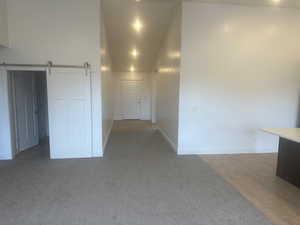 Unfurnished room with hardwood / wood-style floors and a barn door