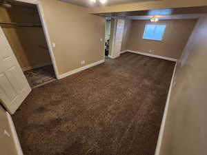 Unfurnished bedroom with dark carpet