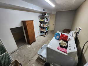 Clothes washing area with washing machine and clothes dryer and a textured ceiling