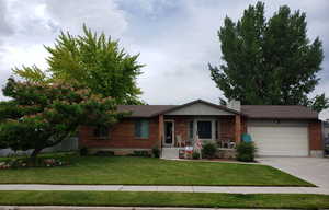 Ranch-style house with a garage and a front lawn