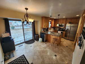 Kitchen featuring sink, stainless steel appliances, pendant lighting, and a breakfast bar