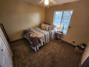 Bedroom featuring dark carpet and ceiling fan