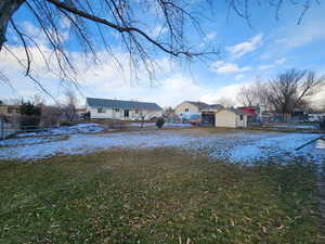 Yard covered in snow featuring a storage shed