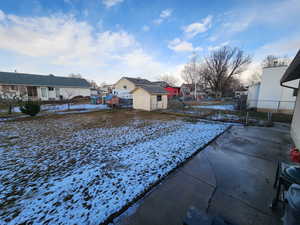 Yard layered in snow featuring a storage shed