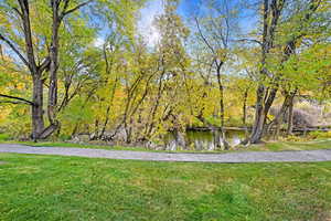 View of property's community featuring a water view and a lawn