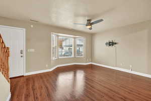 Spare room with ceiling fan, dark hardwood / wood-style flooring, and a textured ceiling