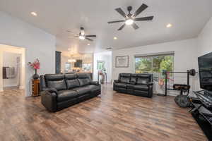 Living room featuring hardwood / wood-style floors and ceiling fan with notable chandelier