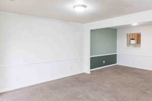 Carpeted spare room with ornamental molding and a textured ceiling