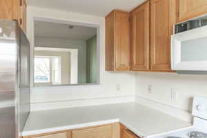 Kitchen featuring stainless steel refrigerator and range