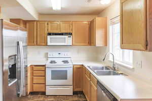 Kitchen with light brown cabinetry, a healthy amount of sunlight, sink, and stainless steel appliances