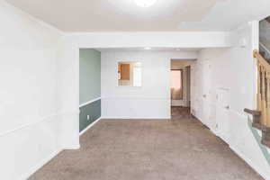 Empty room with a textured ceiling, carpet floors, and crown molding