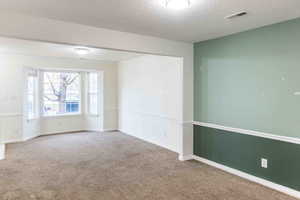 Carpeted empty room featuring a textured ceiling