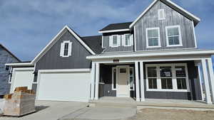 View of front facade with a porch and a garage