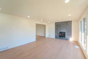 Unfurnished living room featuring light hardwood / wood-style flooring and a fireplace