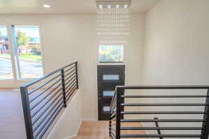 Stairway with an inviting chandelier and hardwood / wood-style floors