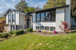 Rear view of property with a lawn