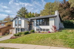 View of front facade featuring a front yard and a garage