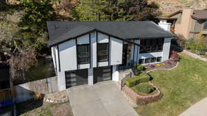 View of front of house featuring central AC, a front lawn, and a garage