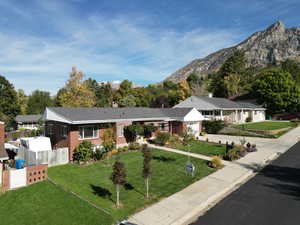 Single story home featuring a mountain view, a front yard, and a garage