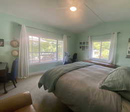 Bedroom with vaulted ceiling and light colored carpet