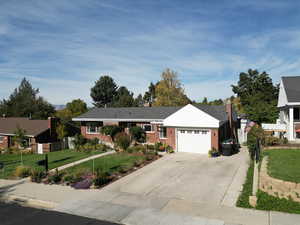 Ranch-style home featuring a front yard and a garage