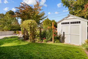 View of yard with a storage shed and a patio area