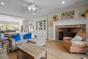 Living room with light hardwood / wood-style floors and ceiling fan