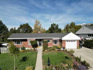 Single story home featuring a front lawn and a garage