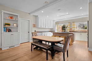 Dining space with sink and light wood-type flooring