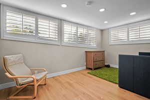 Living area featuring hardwood / wood-style floors and golf simulator