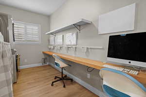 Home office featuring light hardwood / wood-style flooring and built in desk