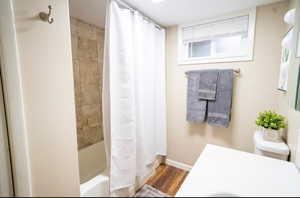 Full bathroom featuring toilet, hardwood / wood-style floors, shower / bath combo, and vanity