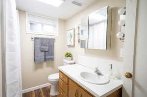 Bathroom featuring vanity, toilet, and hardwood / wood-style flooring