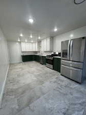 Kitchen featuring green cabinets, sink, white cabinets, appliances with stainless steel finishes, and a textured ceiling