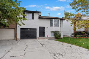 Split foyer home with a front lawn and a garage