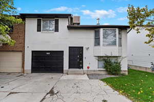 View of front facade featuring central AC unit and a garage