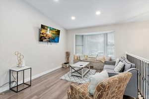 Living room with vaulted ceiling and hardwood / wood-style floors