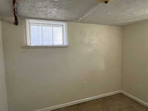 Spare room featuring a textured ceiling and concrete flooring