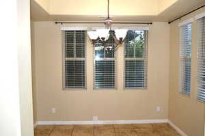 Unfurnished dining area featuring a chandelier and tile patterned floors