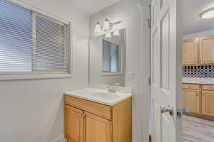 Bathroom with vanity, tasteful backsplash, and wood-type flooring