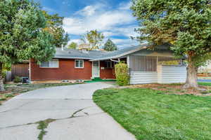 Ranch-style house with a front yard and central AC unit