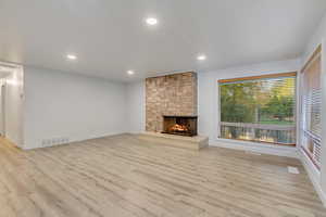 Unfurnished living room with light hardwood / wood-style floors and a fireplace