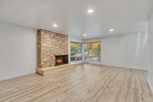 Unfurnished living room with a fireplace and light wood-type flooring