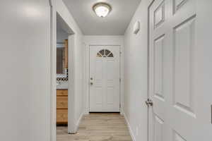 Doorway to outside with light wood-type flooring