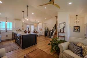 Kitchen featuring white cabinetry, a healthy amount of sunlight, decorative light fixtures, and a kitchen island